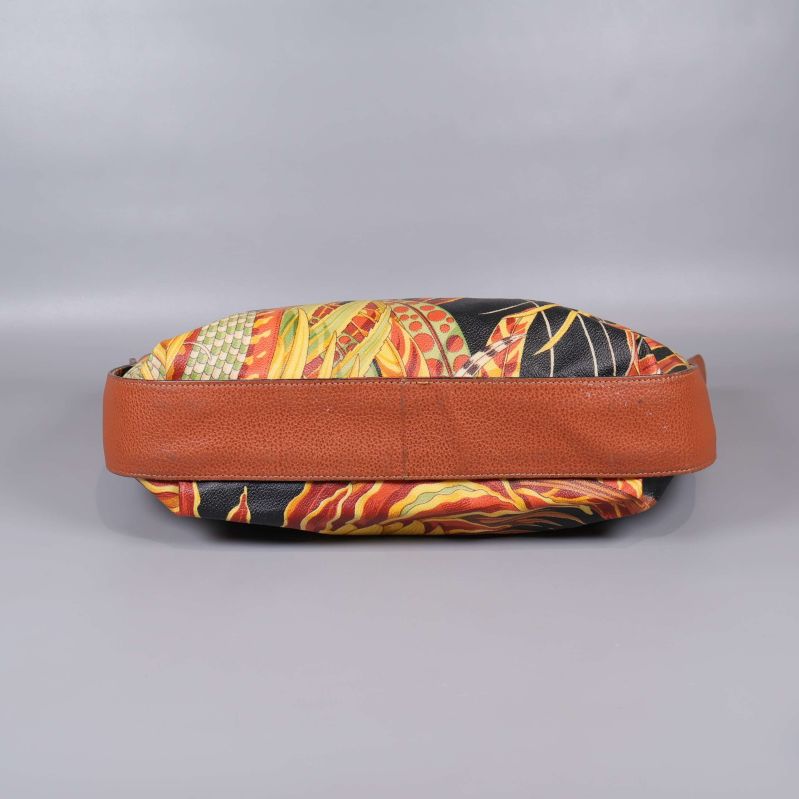 Väskans botten visar mönstrad textil och brunt sidoparti