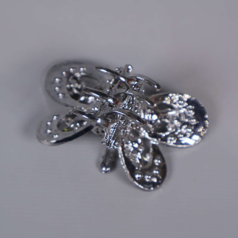 Baksida av fjärilsbrosch med metalldetaljer
