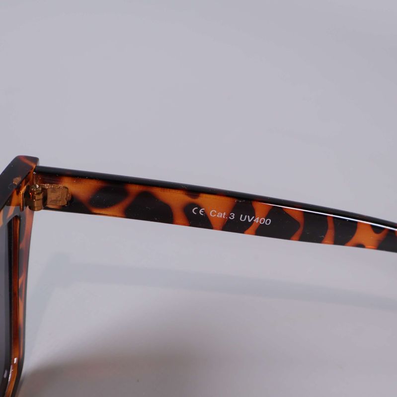 Närbild på solglasögonens skalm med tryckt Cat.2 UV400 text