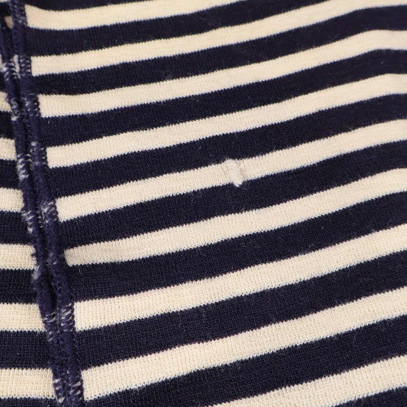 Detaljerat foto av lagning på mörkblå- och vitrandig halsduk