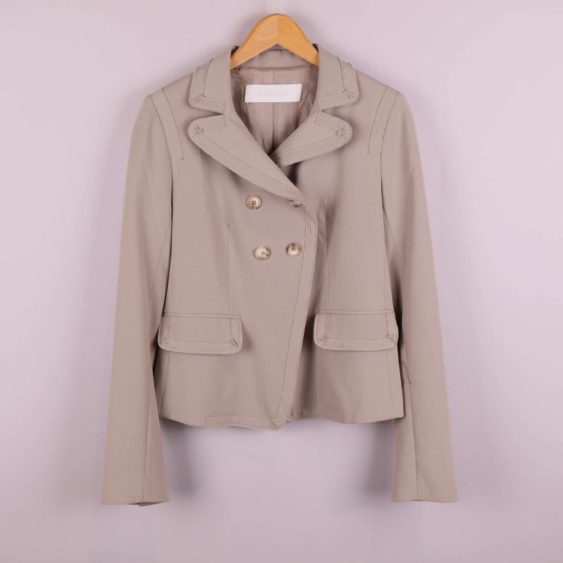 Beige kavaj med dubbelknäppning framtill på galge