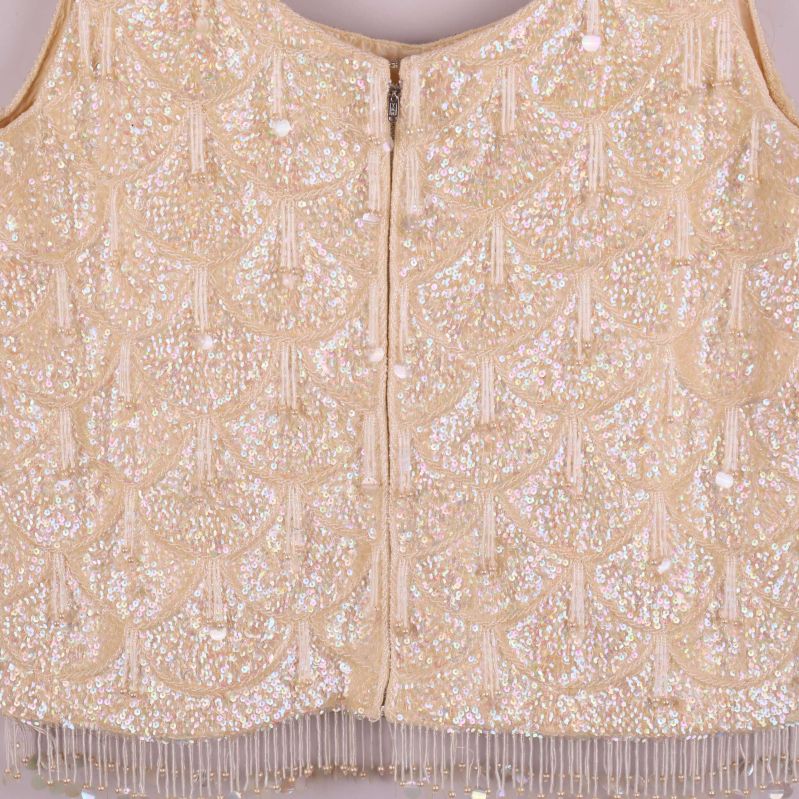 Närbild på pärlbroderi och dragkedja bak