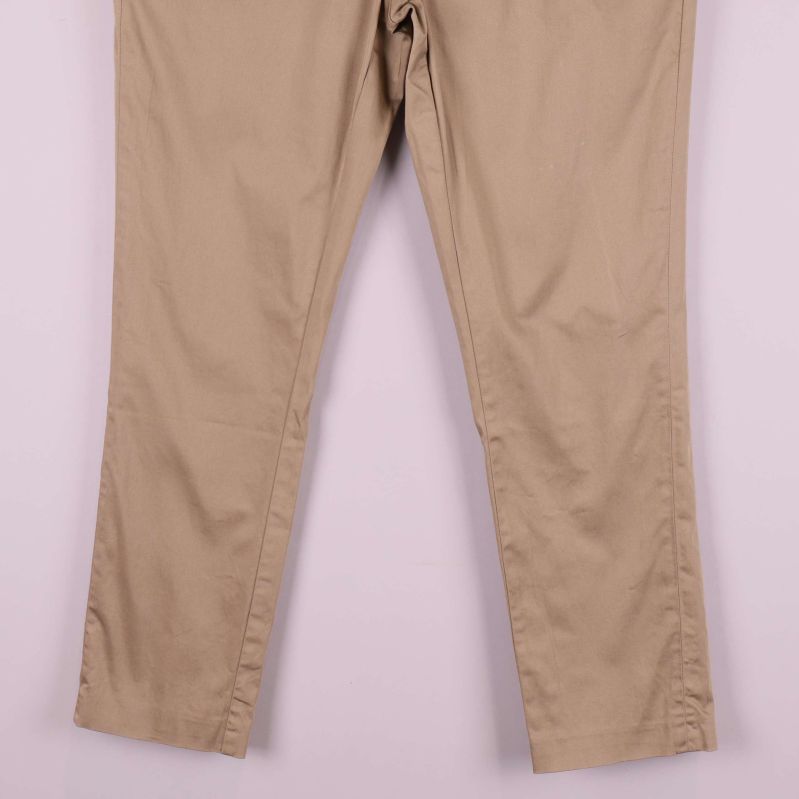 Benavslut på beiga raka byxor i närbild