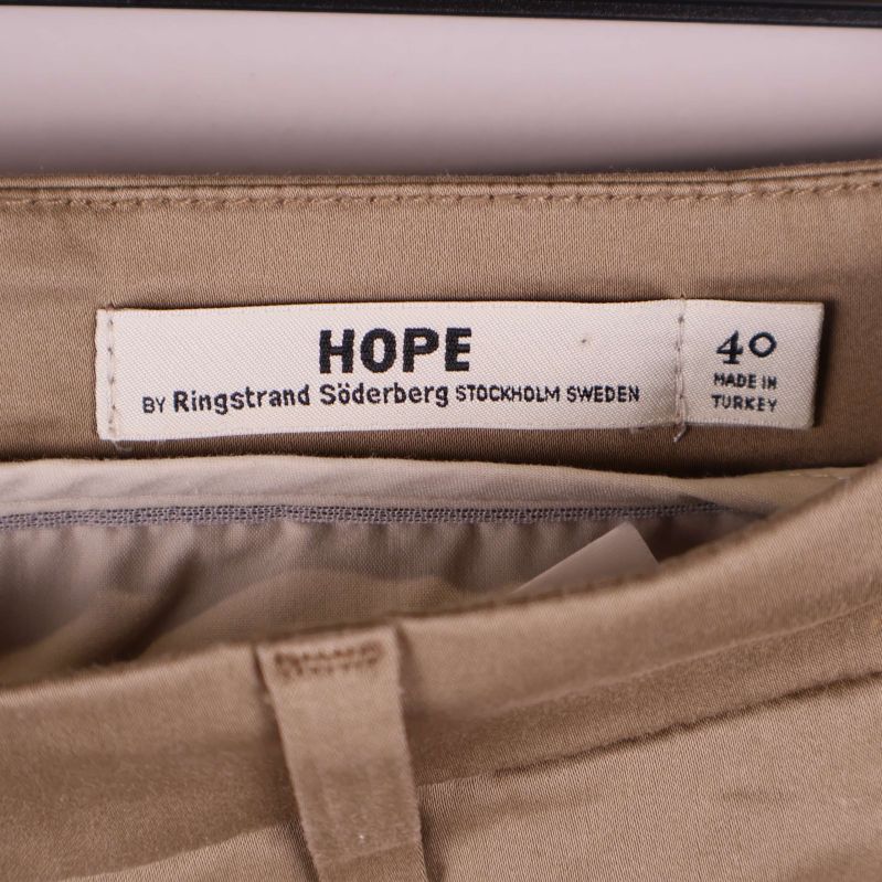 Närbild av Hope-märket och storlekslapp i linningen