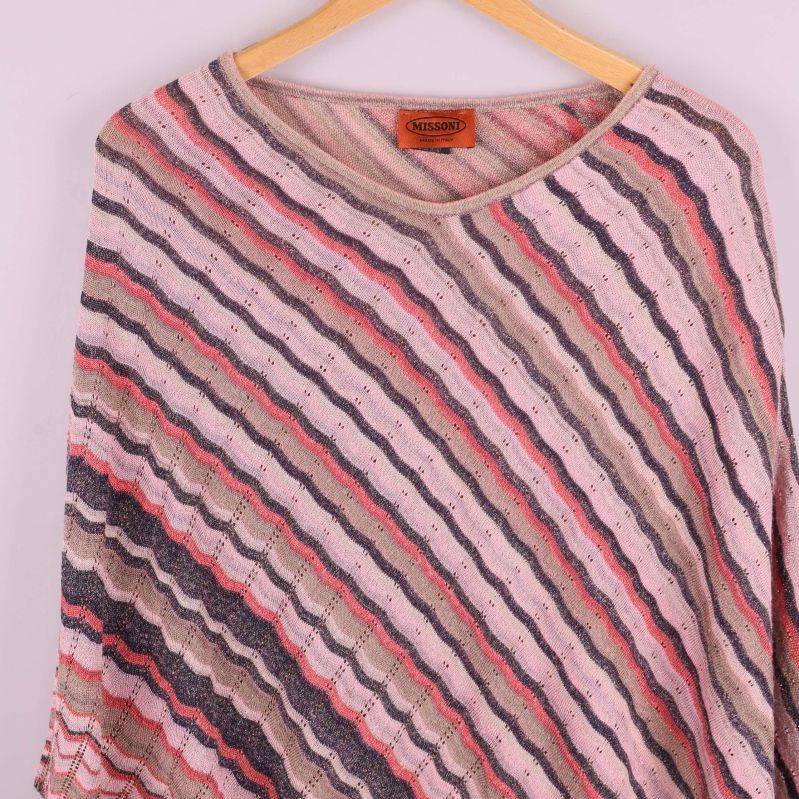 Närbild framsida av poncho med strukturerad stickning och mönster