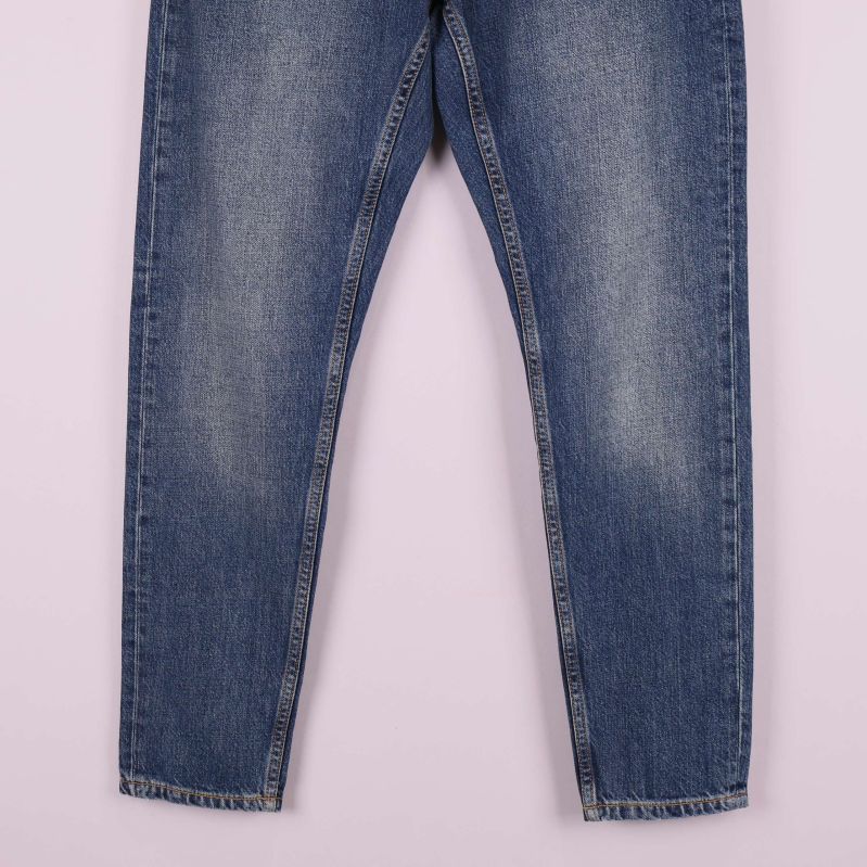 Ben och benslut på blå jeans i närbild