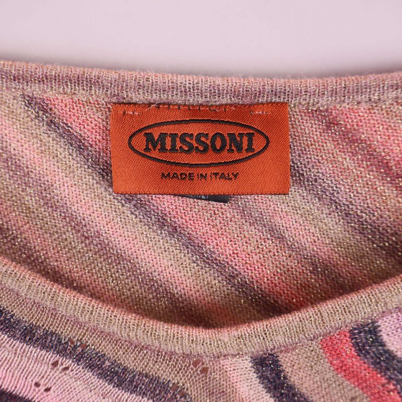 Närbild på Missoni-märket i orange och svart på insidan av ponchon