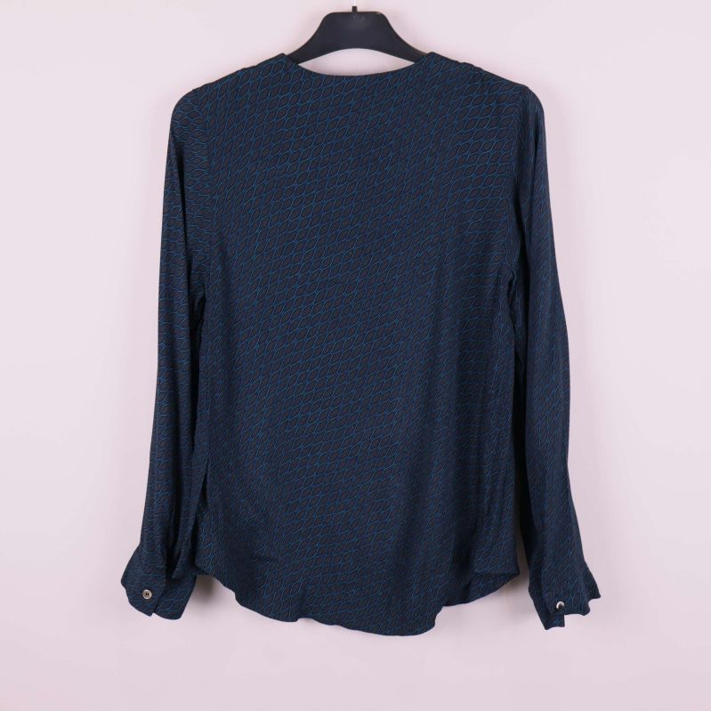 Baksidan av långärmad blåmönstrad topp på galge