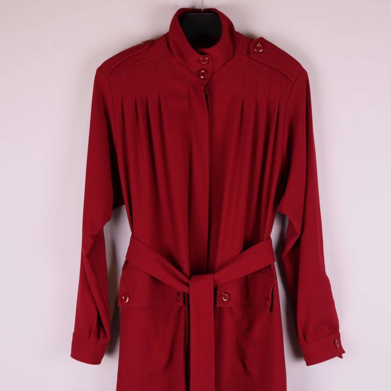 Överkropp och axelparti på röd kappa med knappar