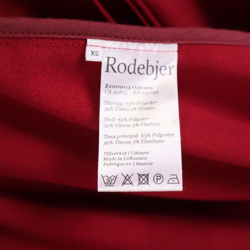 Materialetikett i röd kappa med kompositionsinformation