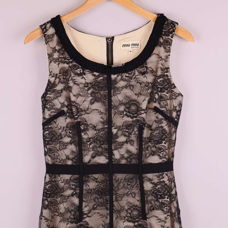 Närbild överdel på klänning som visar spetsen och rund halsringning