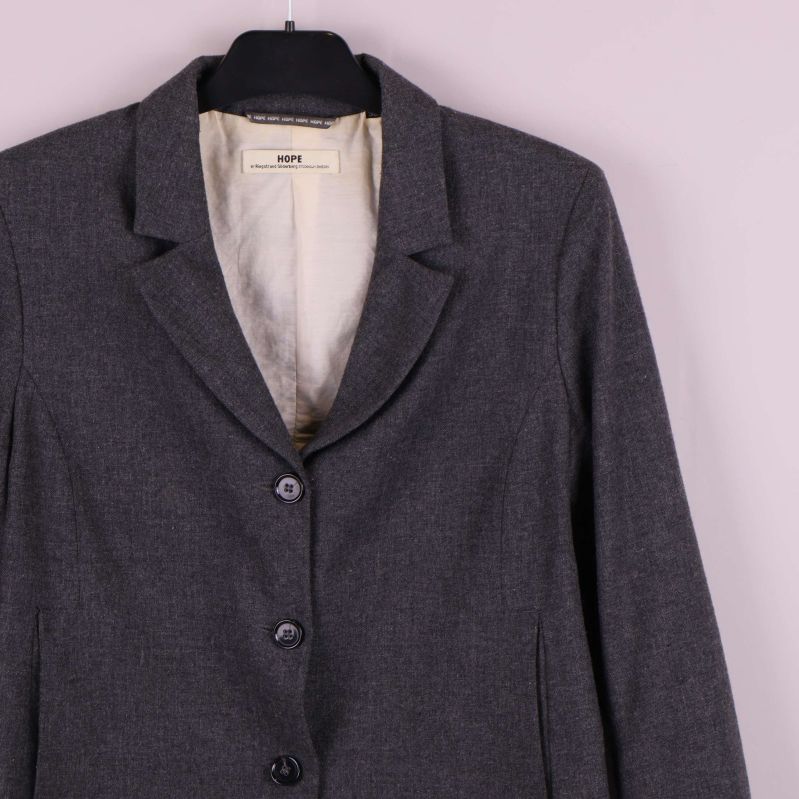 Övre del av grå kavaj och krage med knappdetaljer