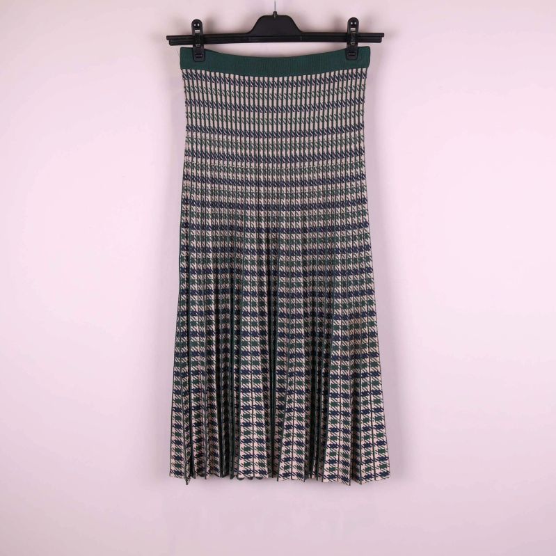 Plisserad kjol med grafiskt mönster hänger på galge