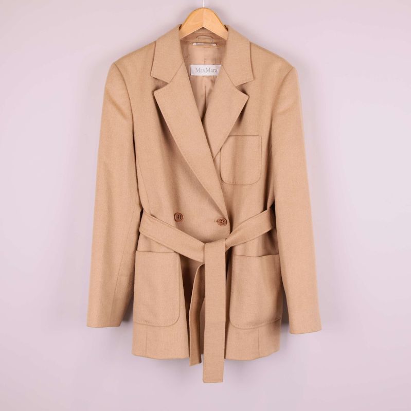 Beige kavaj med bälte framtill på galge