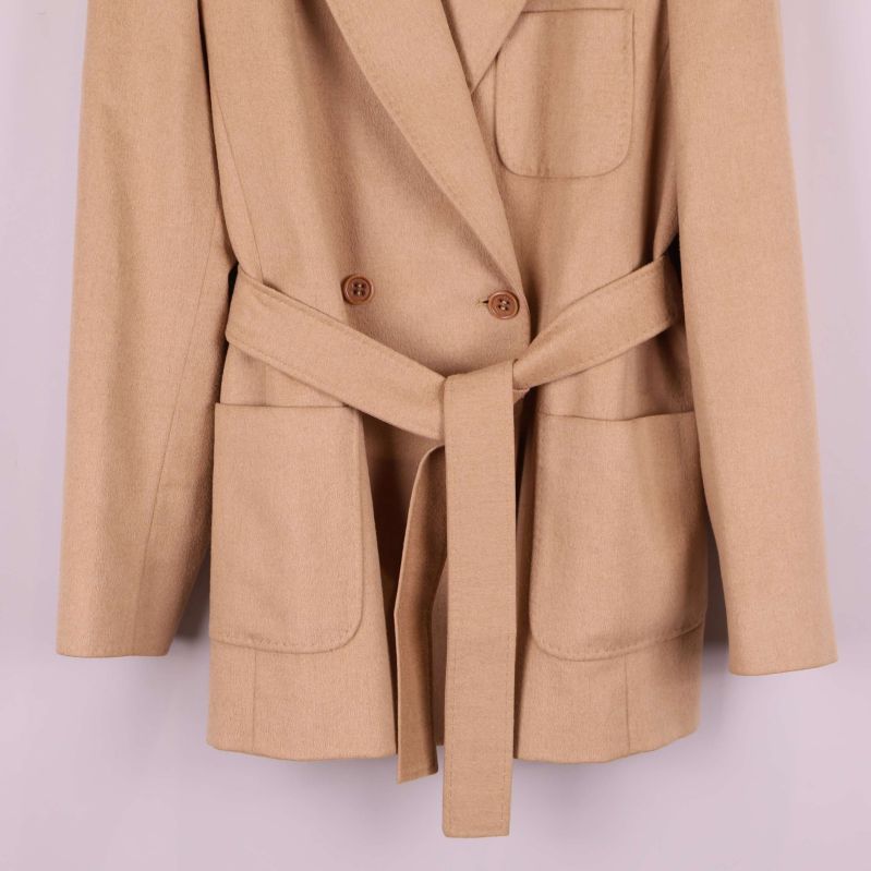 Detaljbild på midjebälte och fickor på beige kavaj