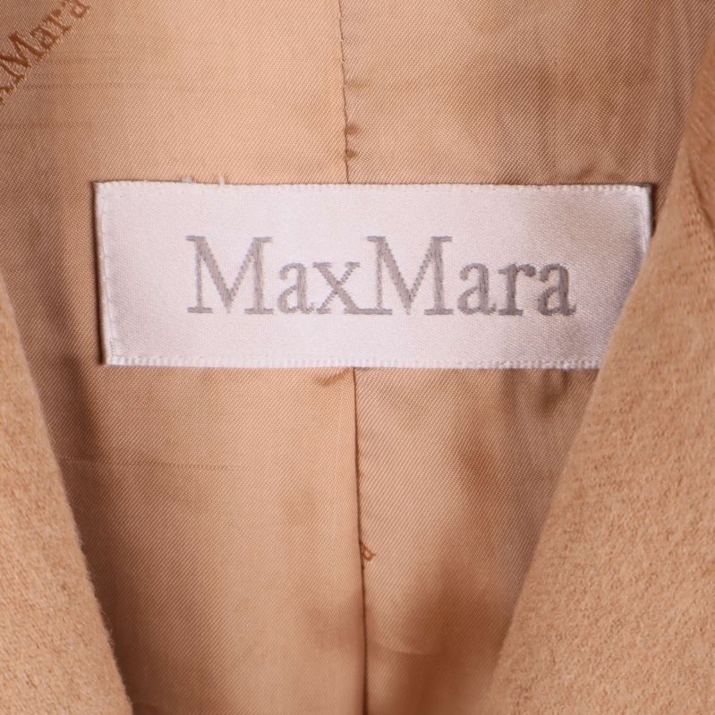 Närbild av MaxMara-etikett i beige kavaj