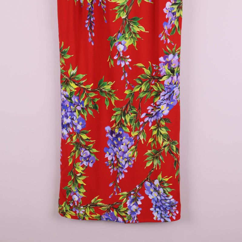 Nedre del av lång röd kjol med blommigt motiv