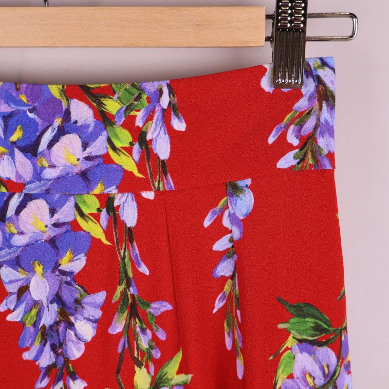 Närbild på midjan och blommigt tyg i rött och lila