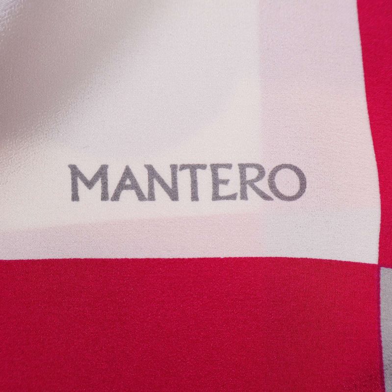 Närbild av Mantero-logotyp på färgglad scarf