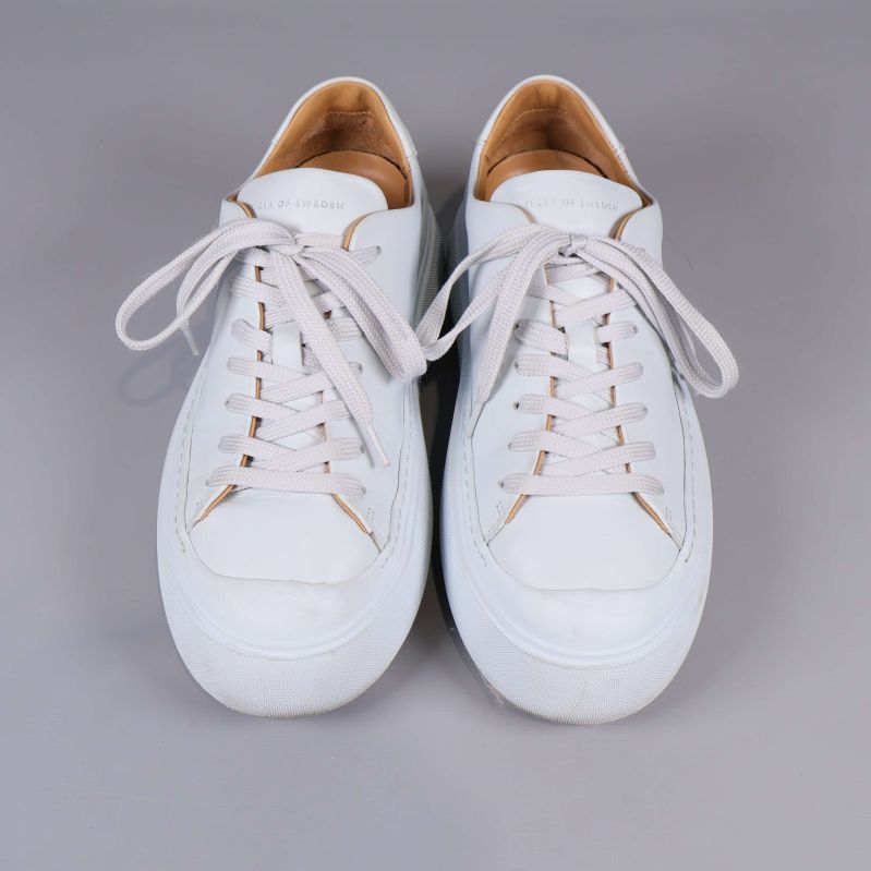 Vita sneakers fotade ovanifrån med snörning synlig