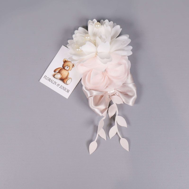 Närbild på blomdekor med vita och rosa blommor samt satinband