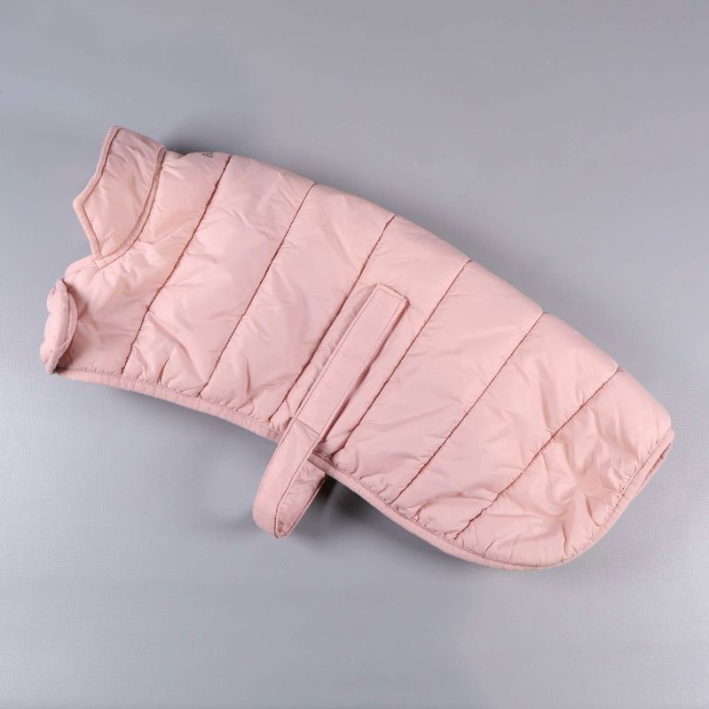 Ljusrosa vadderad hundjacka liggande platt mot ljus bakgrund