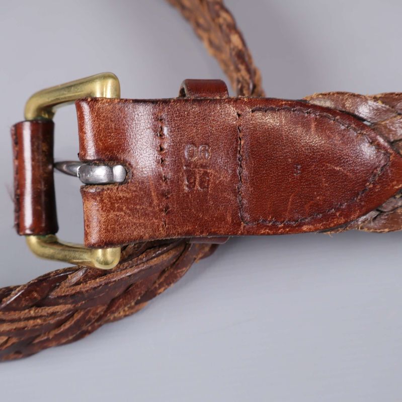 Detaljbild på bältets spänne och präglad storleksmärkning i lädret