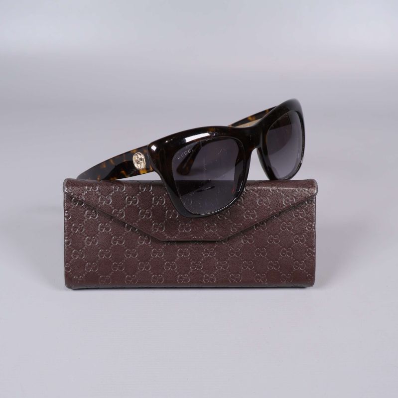 Solglasögon med sköldpaddsmönstrad båge och fodral