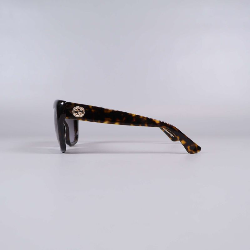 Sida av solglasögon med sköldpaddsmönster och logotyp