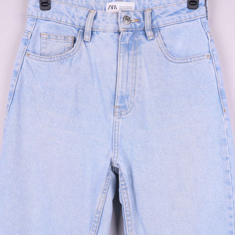 Närbild på jeansens midjedetaljer och fickor