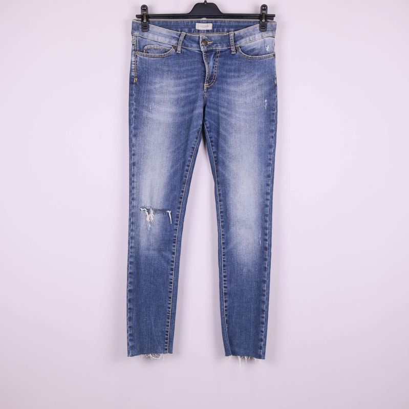 Jeans framifrån med slitningar och råa benslut