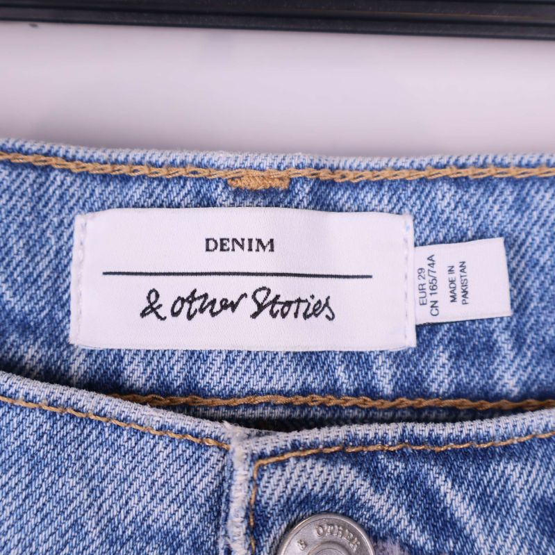 Närbild på märke med texten & Other Stories i linning