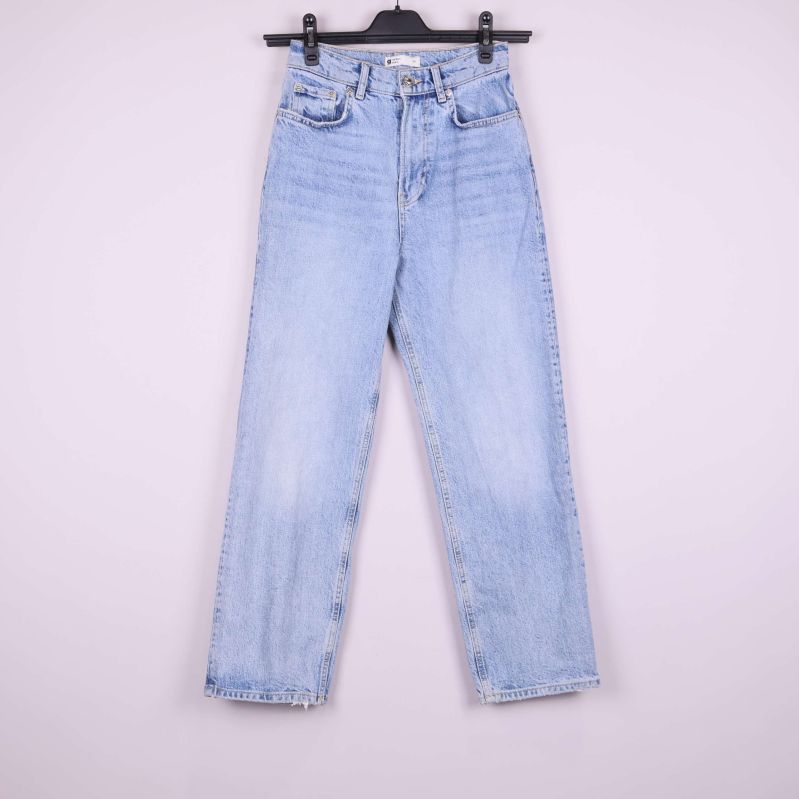 Jeansen framifrån på galge mot ljus bakgrund