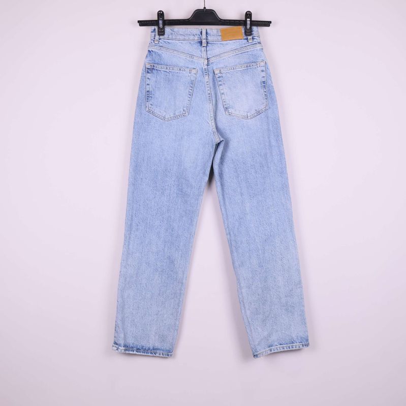 Jeansen bakifrån på galge mot ljus bakgrund