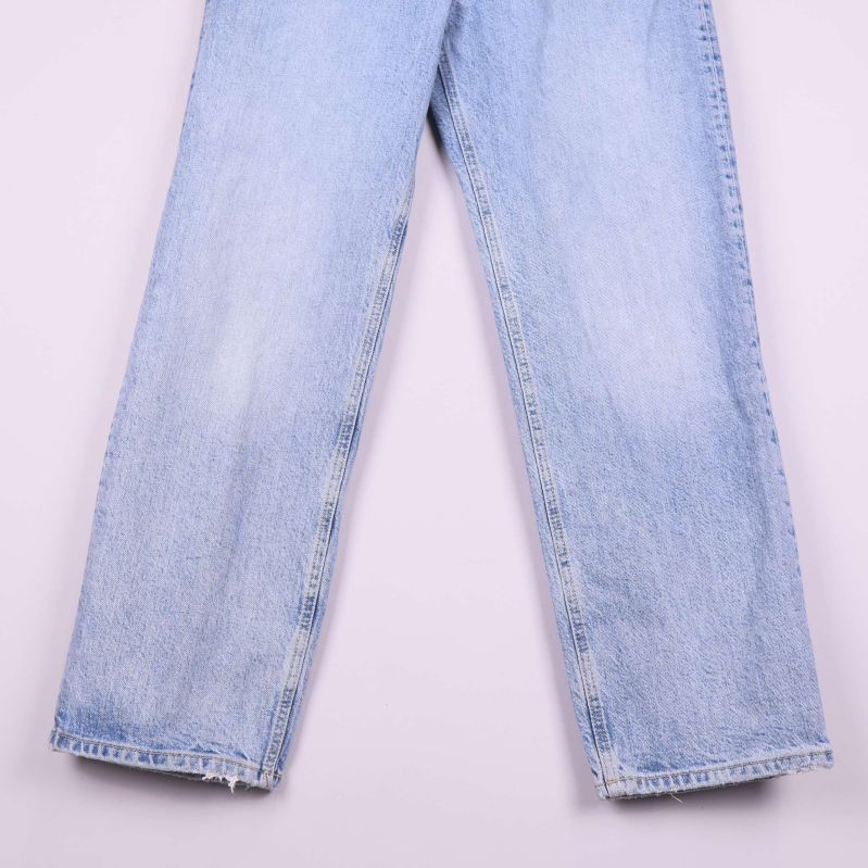 Närbild på jeansens benslut och slitna kanter