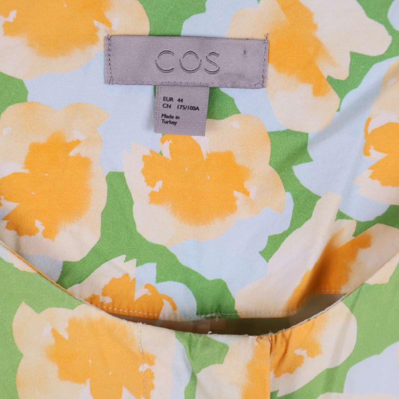 Närbild på COS-märket inuti klänningen