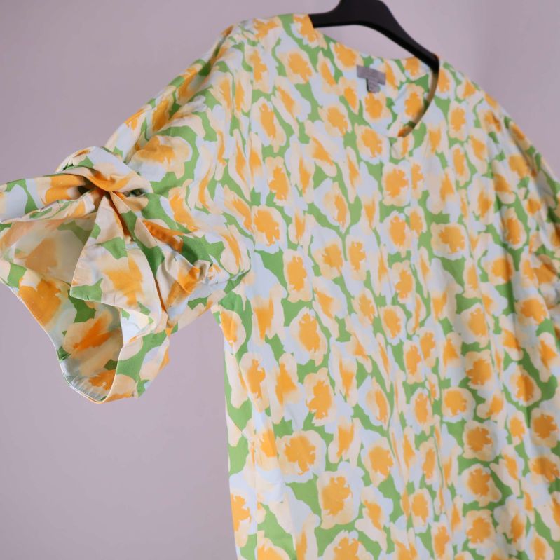 Närbild på ärm med knyt och blommigt tyg