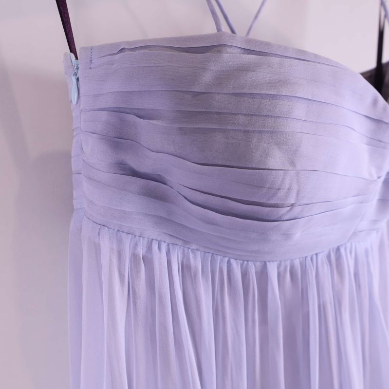 Närbild på överdelens veckade tyg och axelband