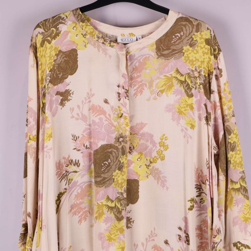 Närbild på överdelen av tunikan med blommigt mönster