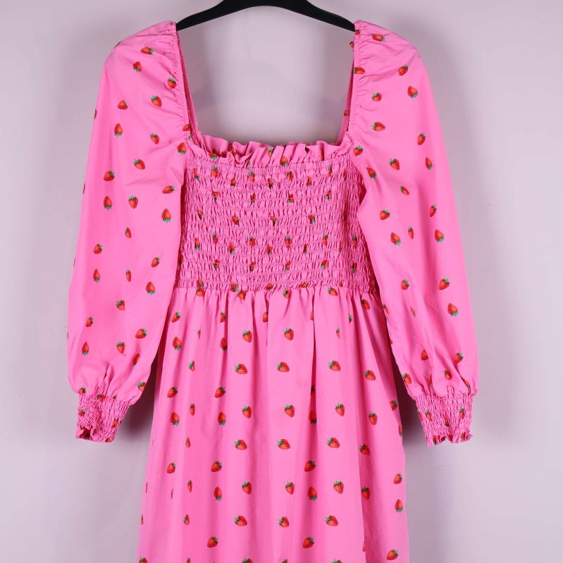 Närbild på överdelen och ärmar med smock i rosa tyg