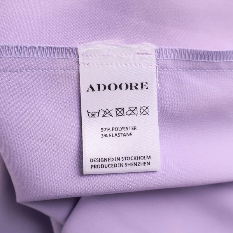 Tvättrådsetikett med material för lila klänning