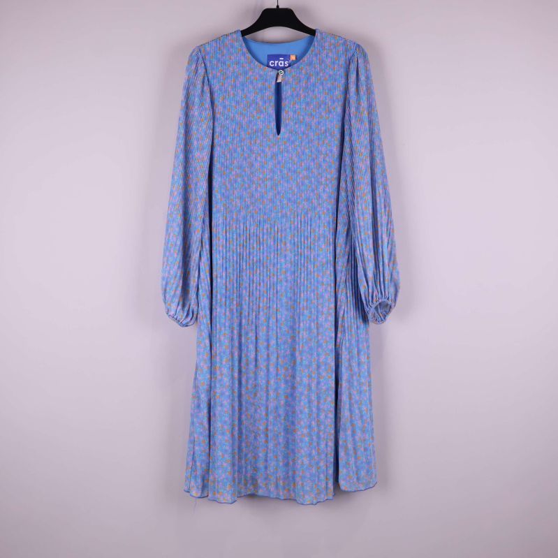 Ljusblå blommig plisserad klänning framifrån på galge