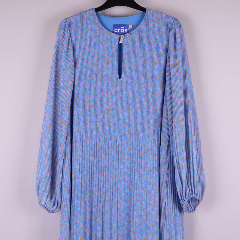 Överkroppsdel på blommig klänning med knappdetalj