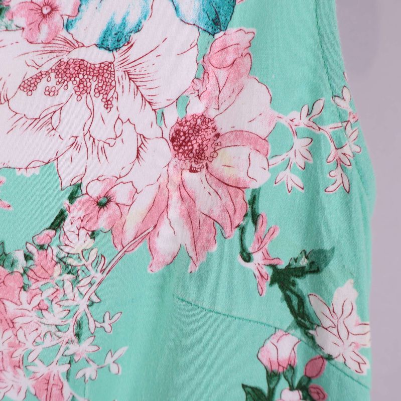 Närbild på blommönster i rosa och vitt på mintgrönt tyg