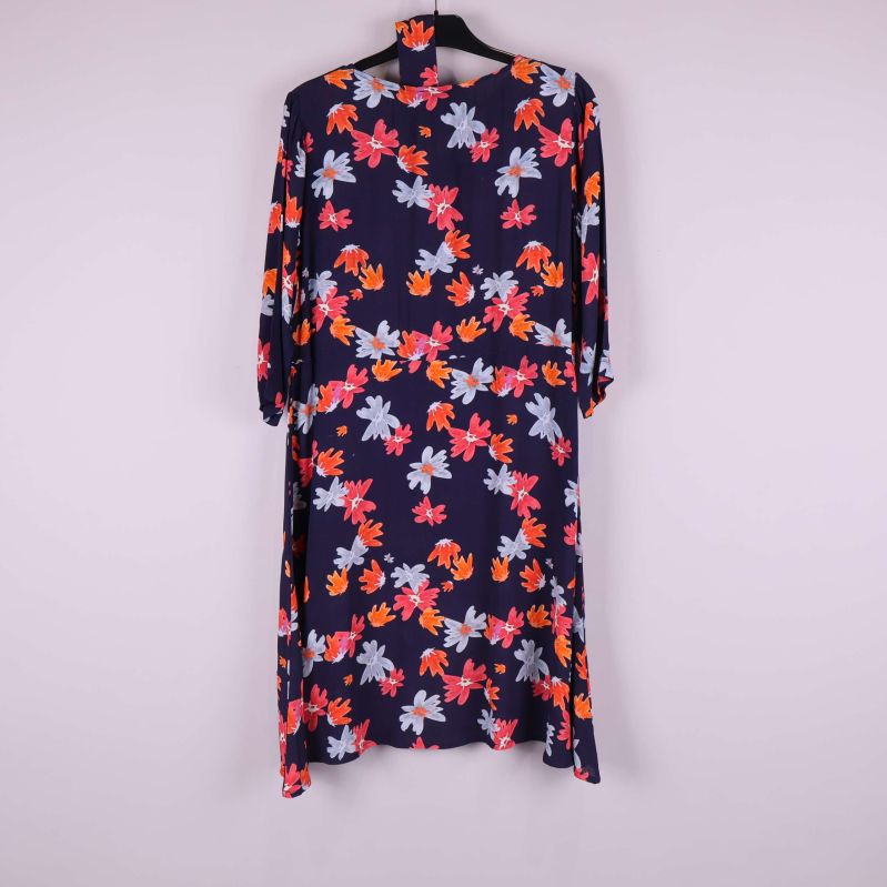 Baksida av blommig marinfärgad klänning med knytband