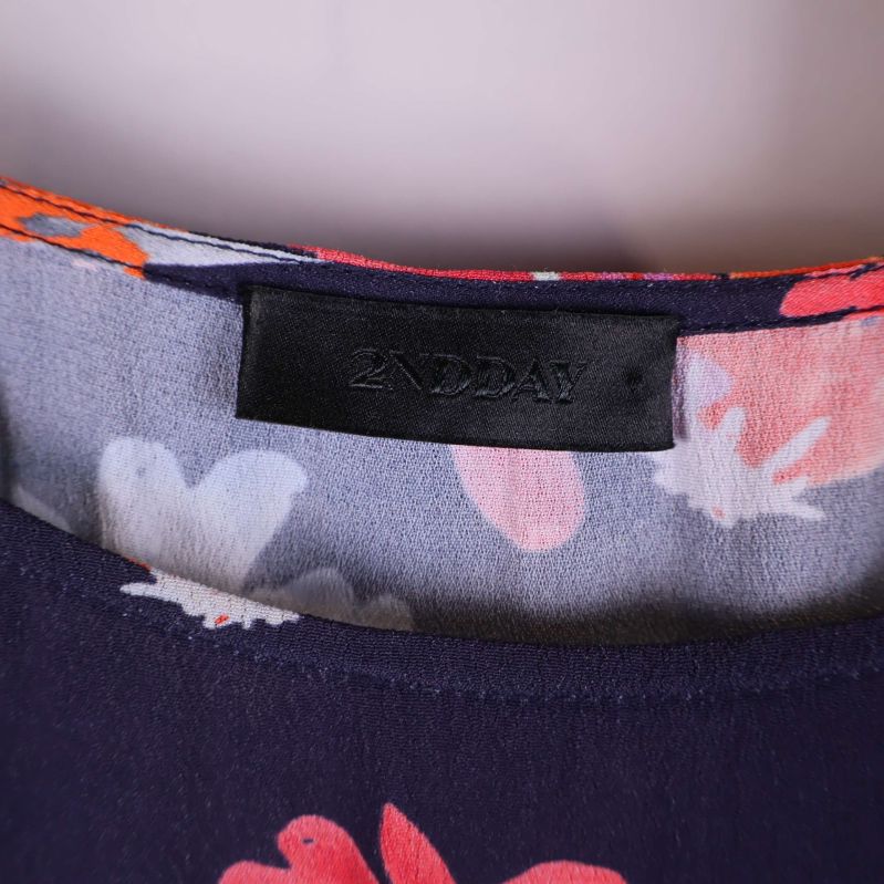 Närbild på 2NDDAY märkesetikett i klänning