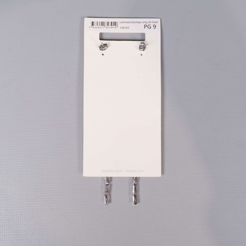 Baksidan på vit kort med örhängen och stift synliga