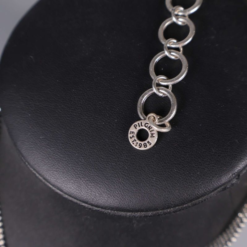 Närbild av märkning Pilgrim EST. 1983 på kedjan