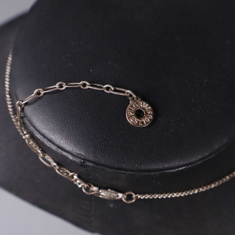 Liten medaljong på kedjan med inskription visas nära