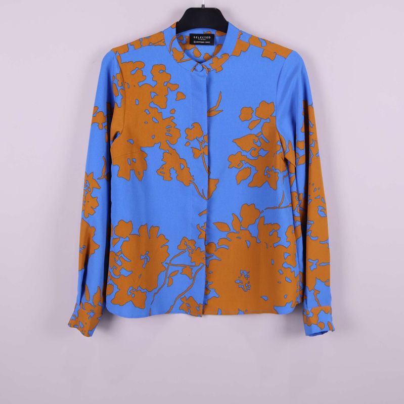 Framsida av skjorta med blå och bruna blommönster på galge